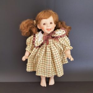 Petite poupée en porcelaine et tissu. H 29cm
